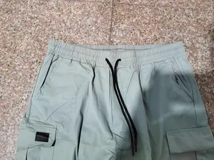 Vista dettagliata dei pantaloncini cargo verde chiaro da uomo con vita elastica