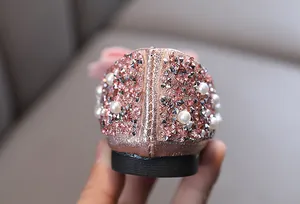 Detailansicht von Mädchen Prinzessin Schuhen mit rosa Glitzer, weißen Perlen und Nieten.