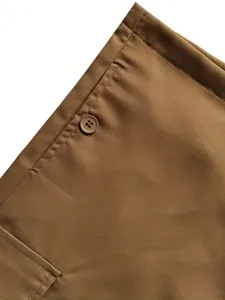 Detaillierte Nahaufnahme von Knopf und Nähten einer braunen Baumwoll-Cargohose für Damen.