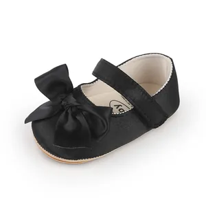 Close-up of black satin baby Mary Jane shoe with a large bow detail for toddlers.