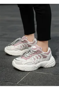 Vista detallada de zapatillas deportivas rosas de malla para niños con suela gruesa.