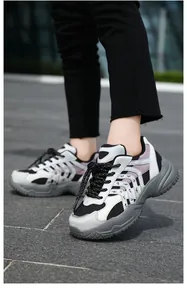 Primer plano de zapatillas dad de malla transpirable para niños con suelas gruesas negras.