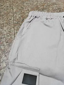 Dettaglio di pantaloncini cargo da uomo con elastico in vita e tasca laterale texture