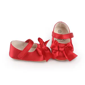 Elegant red satin baby walker shoes featuring a large decorative bow for infants.