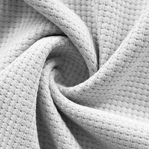 Macro view of light gray waffle textured fabric for casual long sleeve men's shirt