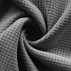 Close-up macro detail of grey waffle-knit fabric texture for men's casual shirt