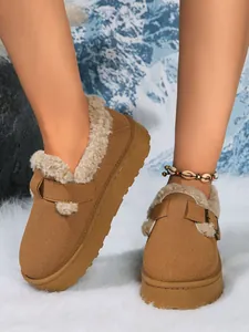 Detailed view of brown suede platform snow boots with cozy faux fur lining and buckle strap.