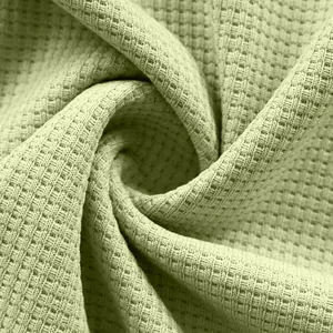 Close-up macro detail of sage green waffle weave fabric for casual men's long sleeve shirts