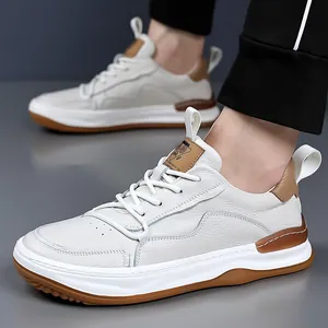 Vue détaillée de baskets en cuir pour hommes blanc cassé avec touches marron et semelle.