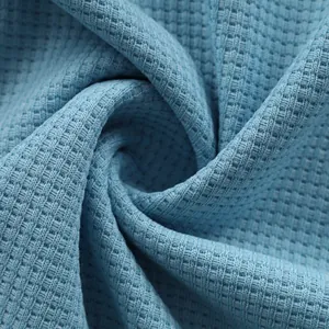 Macro view of blue waffle knit fabric texture for casual men's long-sleeved shirts