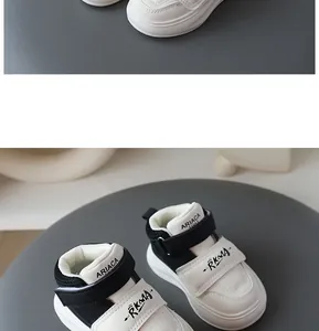 Close-up detail of black and white children's sneakers with hook-and-loop straps