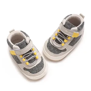 Draufsicht auf graue und gelbe Freizeit-Lauflernschuhe mit weicher Sohle für Babyjungen