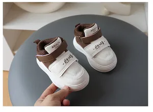 Close-up detail of stylish brown and white toddler sneakers featuring soft soles and Velcro straps