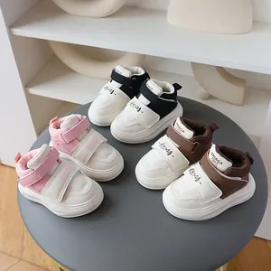 Detailed view of stylish toddler sneakers in pink, black, and brown with velcro straps