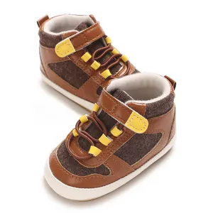 Detailansicht brauner Baby-Lernlaufschuhe mit weicher Sohle und gelbem Klettverschluss.
