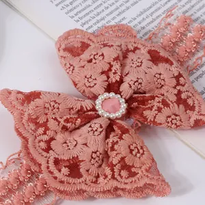 Macro detail of elegant pink lace floral headband with pearl center for baby girls