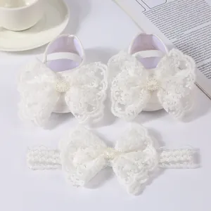 Detailed view of white lace baby princess shoes and matching bow headband gift set