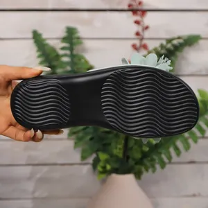 Primo piano della suola nera antiscivolo con texture ondulata dei sandali floreali
