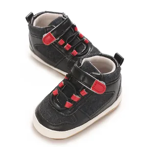 Nahaufnahme von weichen Baby-Lernlaufschuhen in Schwarz und Rot mit Klettverschluss