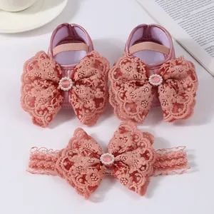 Detail view of pink lace bow baby shoes and matching elastic headband set