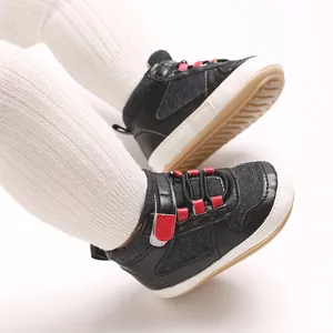 Detailansicht von Baby-Lauflernschuhen mit weichen Sohlen, schwarzem Leder und roten Akzenten
