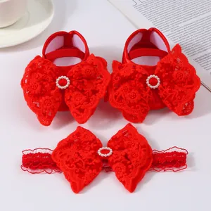 Detailed view of red baby princess shoes with lace bows and matching headband set