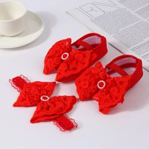 Detail of red baby princess shoes and matching headband set with lace bows and pearls