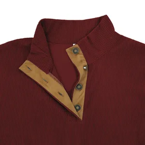 Macro detail of men's burgundy corduroy sweatshirt featuring stand-up collar and button placket