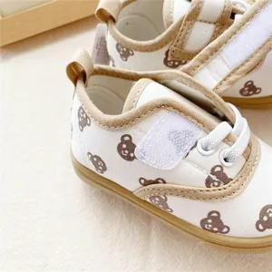 Close-up detail of children's canvas shoes with cute bear pattern and velcro strap.