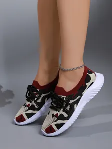 Detalle de zapatillas de deporte para mujer de flyknit camuflaje con suela blanca gruesa.