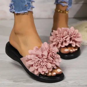 Dettaglio della decorazione floreale in tessuto rosa su questi sandali con plateau