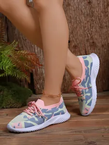 Primer plano de zapatillas de punto para mujer con suela gruesa y patrón de camuflaje colorido
