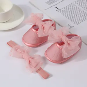 Primer plano de zapatos de princesa rosas para bebé y conjunto de diadema con lazo