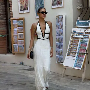 Fashionable contrast-colored V-neck halter backless knitted maxi dress on street.