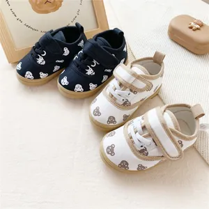 Cute bear pattern children's canvas shoes with convenient velcro straps in black and white.