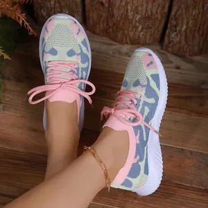 Pastelgekleurde gebreide sportschoenen voor dames met dikke witte zolen op hout