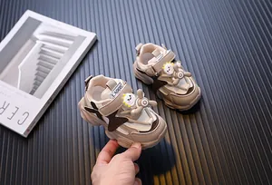 Detailansicht der beigen Kinder-Sneaker mit Cartoon-Design und rotierendem Spielzeug