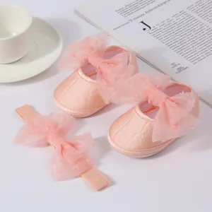 Primer plano de zapatos de princesa rosas para bebé con lazos de tul y diadema
