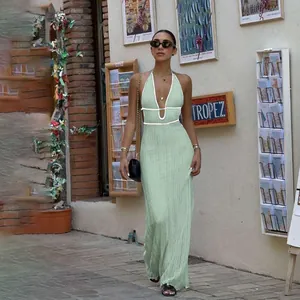 Fashionable green knit halter maxi dress with contrast white trim on a street walk