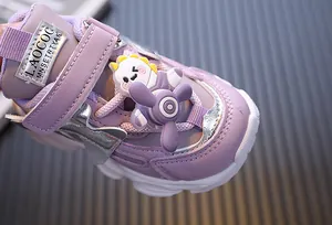 Detailansicht lila Kinder-Sportschuh mit Cartoon-Dino und drehendem Propeller