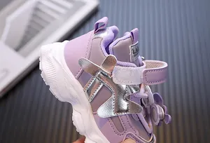 Detailansicht der lila Kindersneaker mit silbernen Akzenten und Blumen-Anhänger.