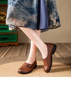 Close-up of brown elderly leather loafers with vintage button detail and soft sole
