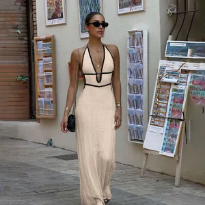 Full length view of the beige halter neck knit dress with black piping detail