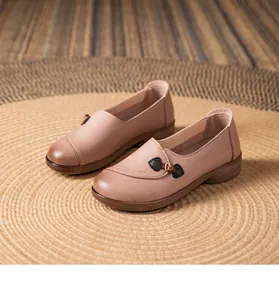 Detail of soft leather flat shoes for elderly women with decorative knot button