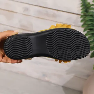 Primo piano della texture antiscivolo nera sulla suola dei sandali a fiori da donna di qualità