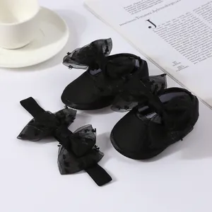 Detalle exquisito de zapatos de princesa negros para bebé con lazos de malla y diadema