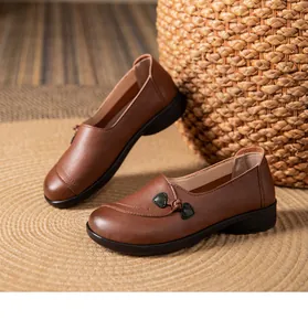 Close-up of brown leather flat loafers with decorative knot detail and soft sole