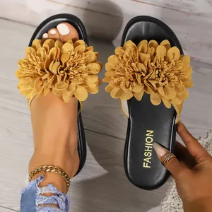 Vista dettagliata di sandali piatti da donna con grandi decorazioni floreali gialle