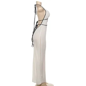 Side view of a white knit halter maxi dress with black contrast straps and backless design