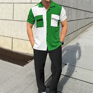 Detail of green and white color-block corduroy shirt with pockets and black trousers.